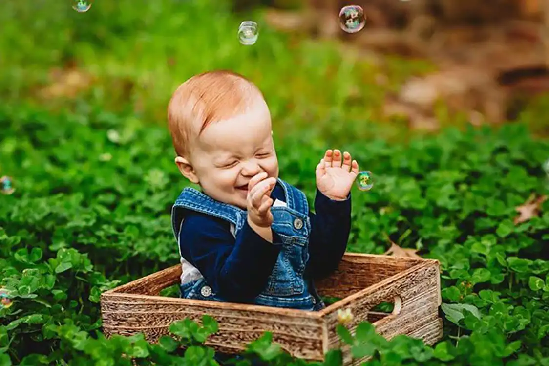 Happy baby in a basket with bubbles